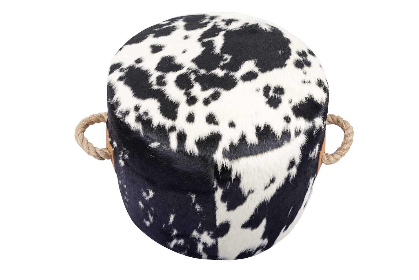 round cowhide ottoman with a natural black and white spotted pattern and tan leather tabs on the sides with thick, jute handles